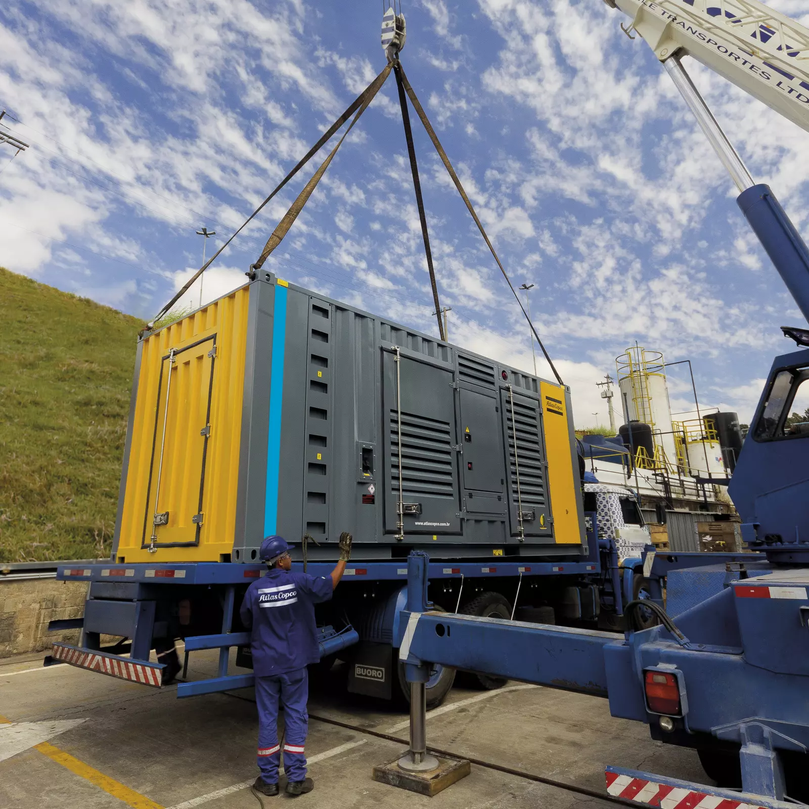 Heavy machinery movers relocating industrial equipment using specialized lifting gear