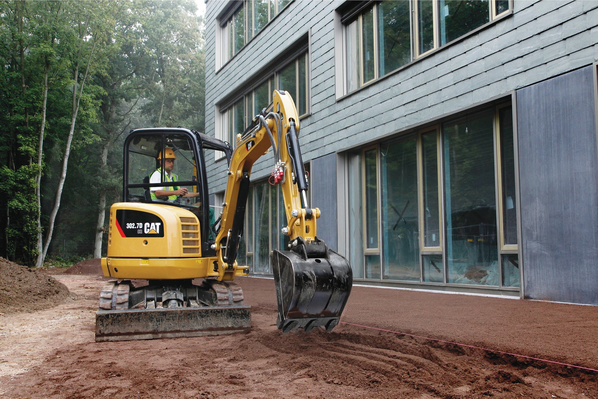 A pile of loose sand next to a deep hole during digging a pool, demonstrating the volume of displaced earth.