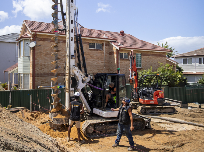 A neat row of pre-drilled holes ready for solar panel pile drilling, showcasing the precision alignment achieved by professional contractors. Description: The "After" shot showing alignment perfection.