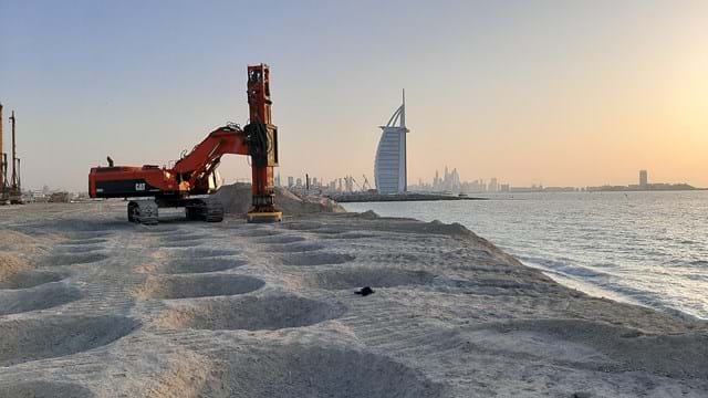 A side-by-side comparison: A compact Bobcat skid steer working in a garden versus a massive Motor Grader working on a highway project.