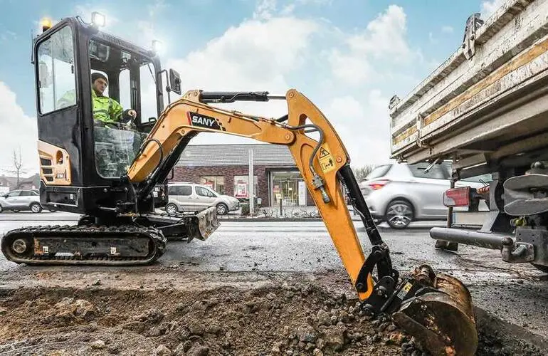 A 1-ton micro excavator rental Dubai unit driving through a standard office doorway with its tracks retracted, ready for indoor demolition work.