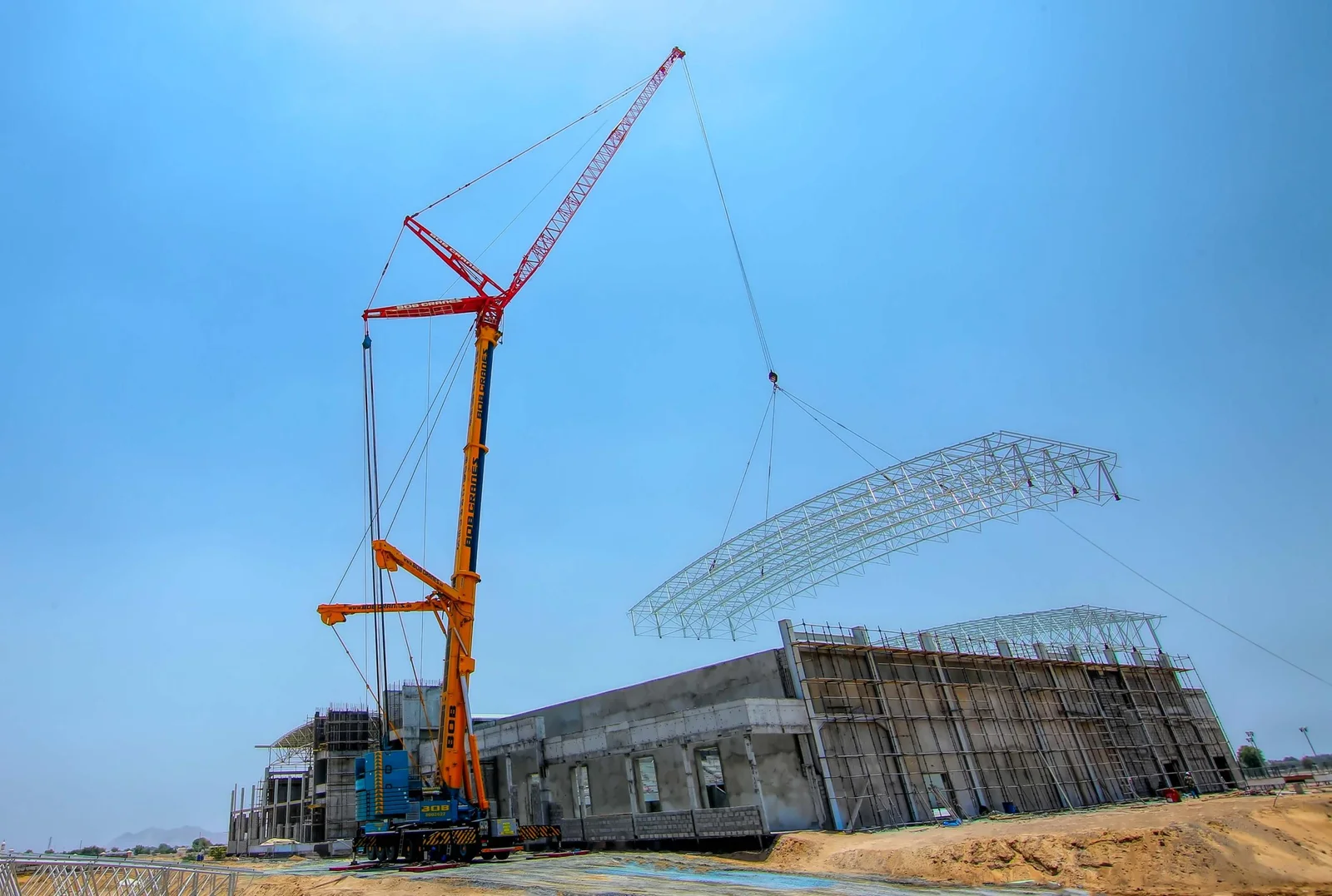 An external furniture lift hire machine (ladder lift) moving boxes and chairs to a second-floor window.