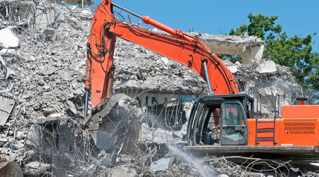 Heavy graders and bulldozers performing clearing and grubbing for road construction in a Dubai desert landscape.