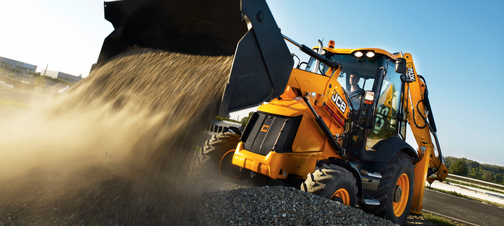 A professional JCB operator giving a thumbs up from the cab, representing the skilled workforce included in JCB machine hire.
