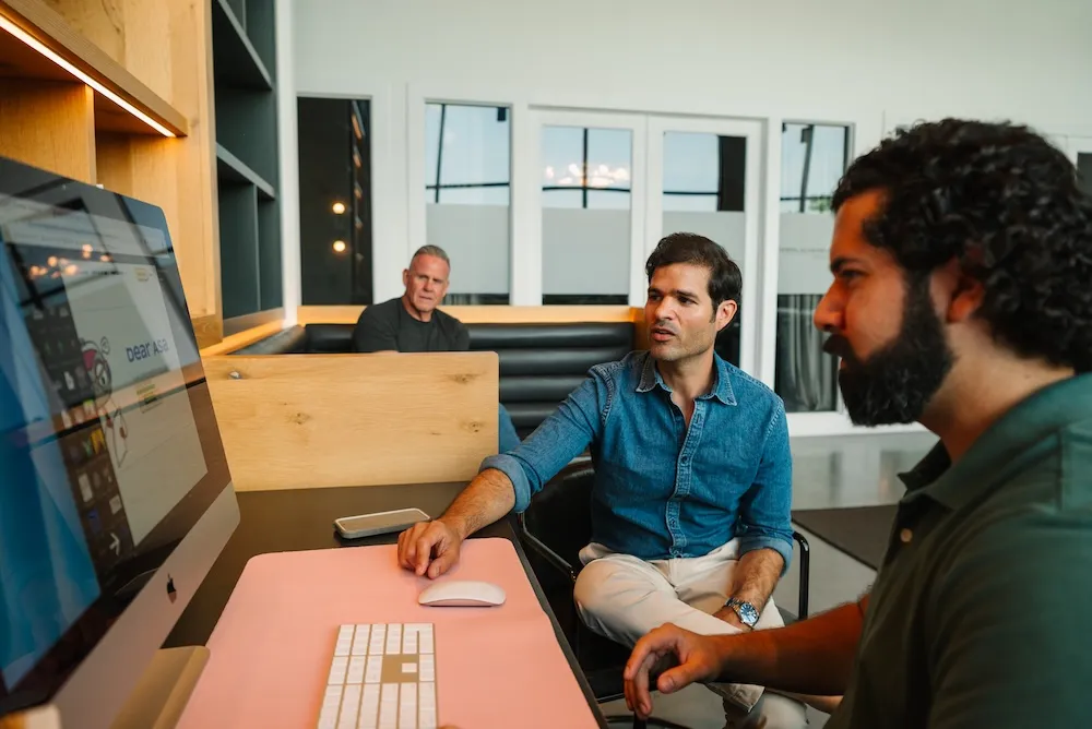 Barrena Branding team reviewing work at a shared desk