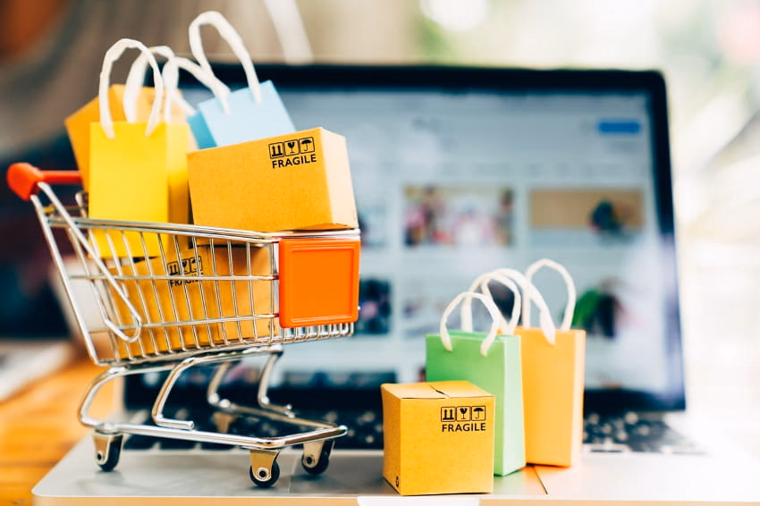 laptop screen with small shopping cart and several packages indicating an increase in average order value for e-commerce