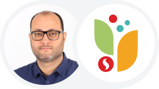 Headshot of a man with glasses next to a logo with red circles, green leaves, and an orange shape.
