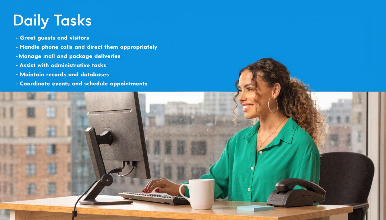A professional receptionist sitting at her desk, typing on a computer, and smiling in an office setting.