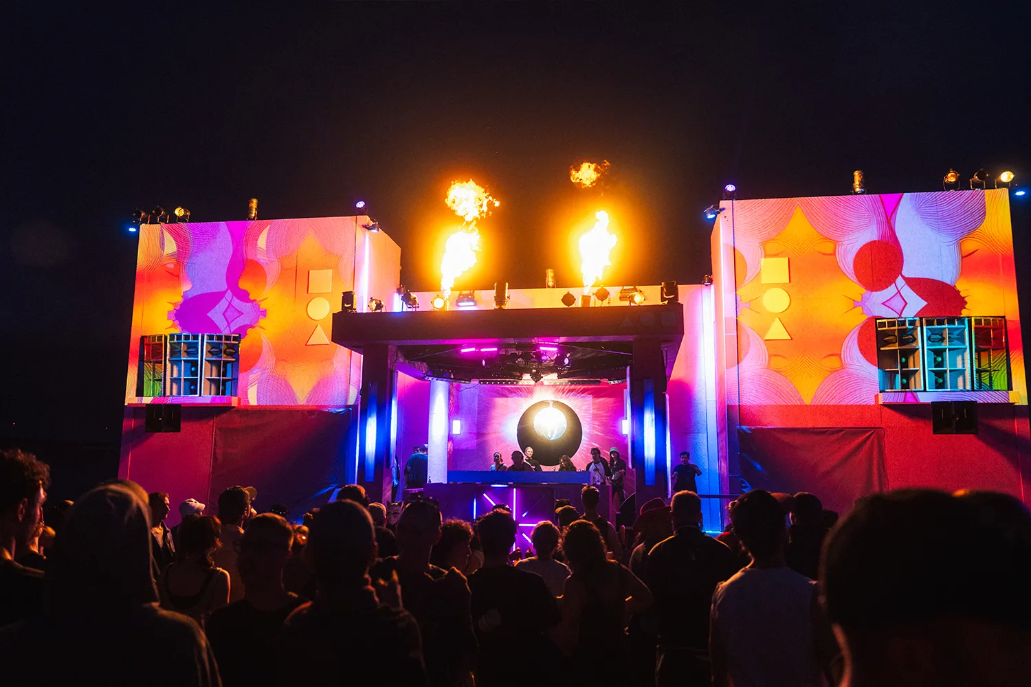 Eine Bühne, die aussieht wie Bauklötze. Davor tanzen Menschen.