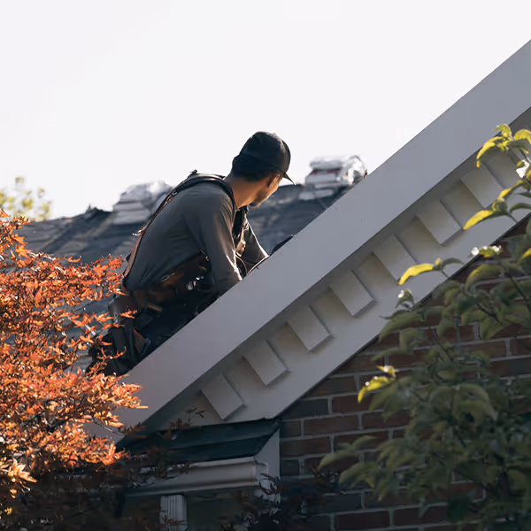 Professional roofer inspecting roof shingles