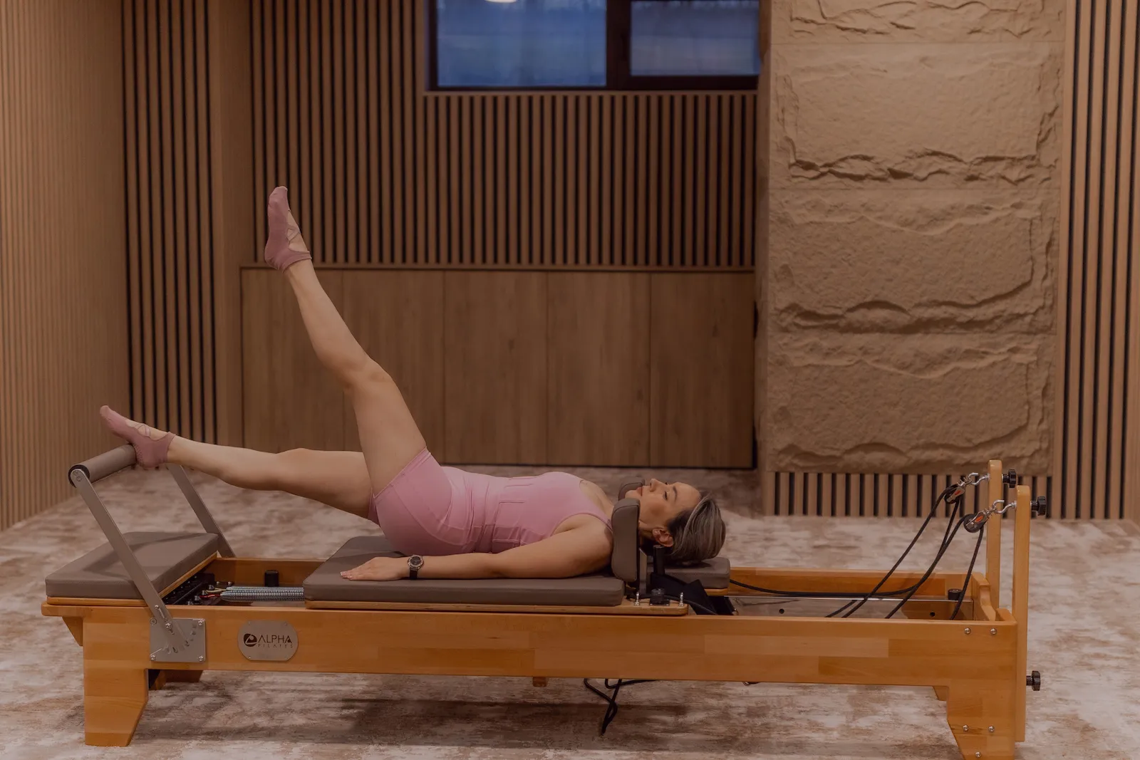Femeie practicând reformer pilates