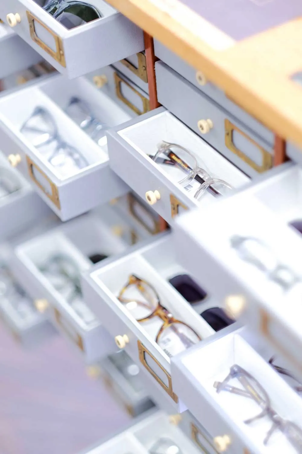 Organized white drawer system with eyeglasses in individual compartments