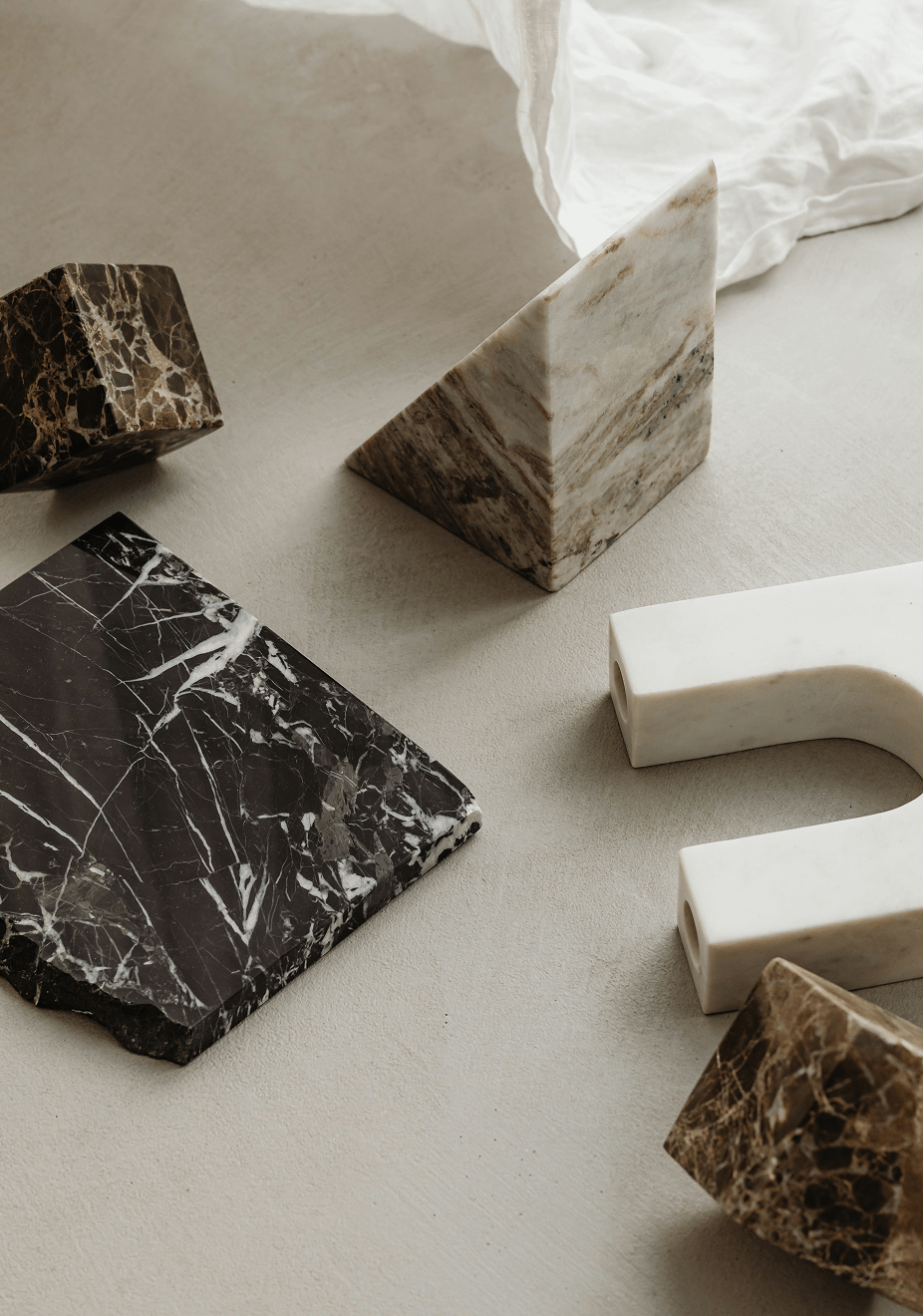Decorative geometric marble figures, white fabric on concrete table