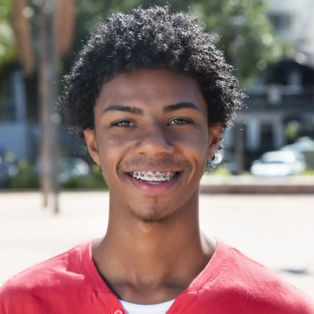 A young man with a smile and braces on his teeth.