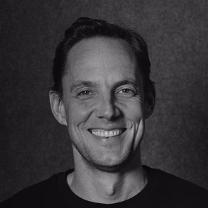 Black and white portrait of Erik De Winter against a dark background.