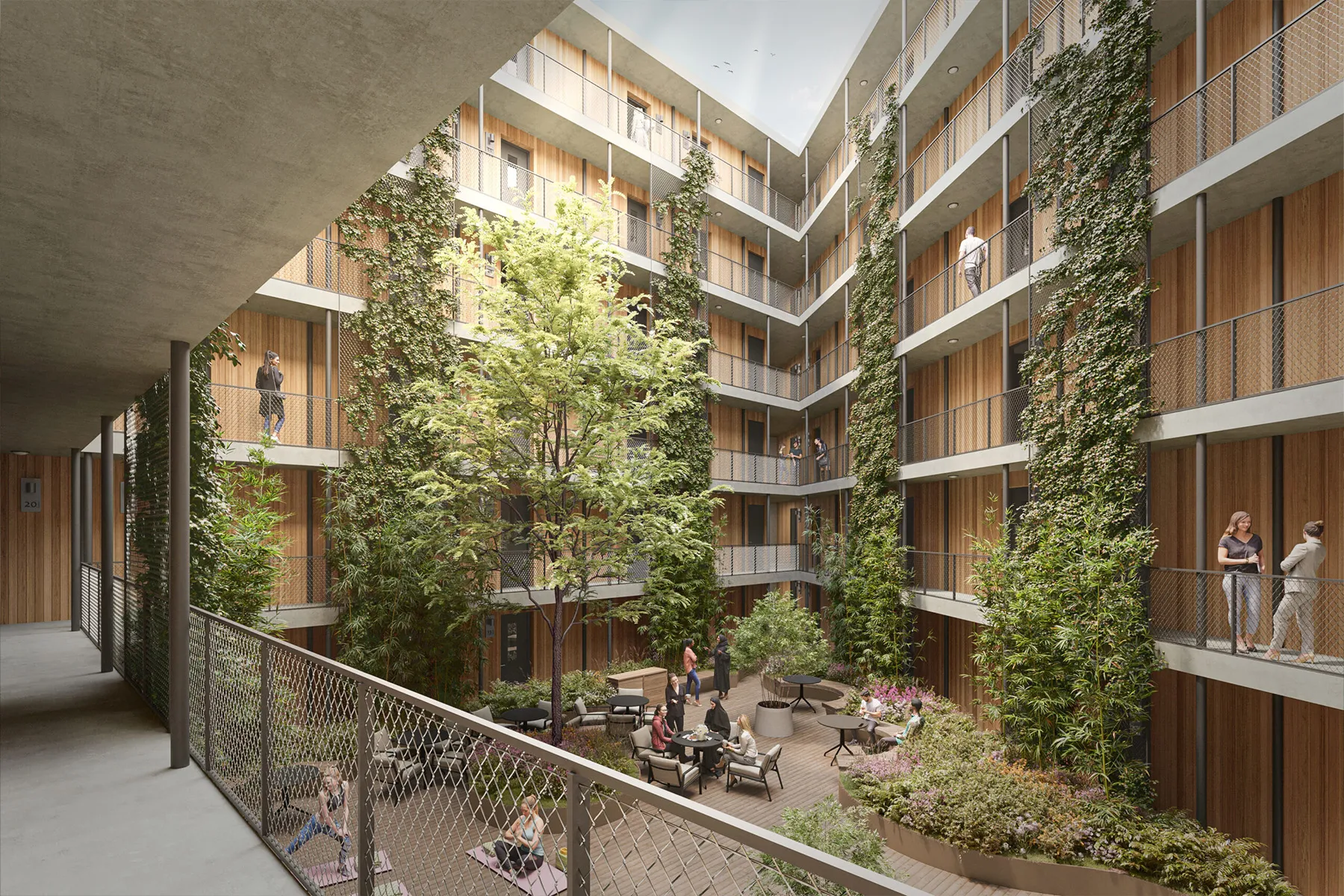 Binnenhof van een woongebouw met balkons, loopgangen, bomen, beplanting, zitplekken en aanwezige mensen.