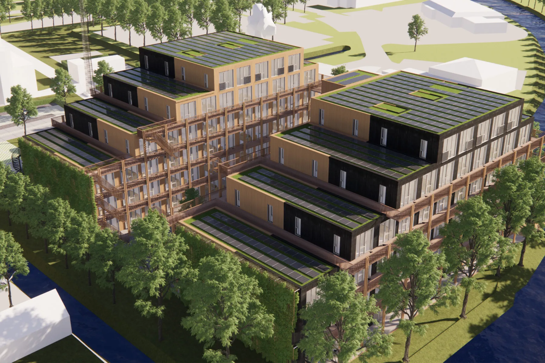 Luchtfoto van getrapte woongebouwen met balkons, begroeiing op de daken, omliggende bomen en water langs de randen.