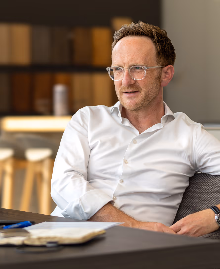 Ralph Steffens, Berater für den Küchenhandel, sitzt am Tisch mit Notizbuch und Stift, Blick nach rechts.