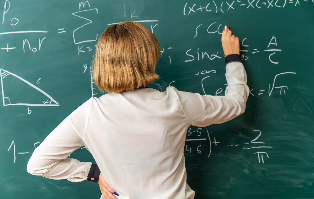 Frau schreibt mathematische Formeln an eine Tafel, Fokus auf Geometrie und algebraische Ausdrücke.