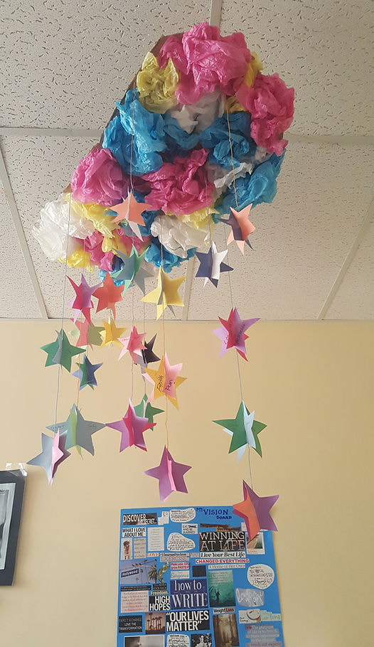 A ceiling adorned with colorful paper stars and flowers, creating a festive and whimsical atmosphere.