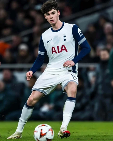 Football player in a white Tottenham Hotspur kit with AIA logo controlling the ball on the field.