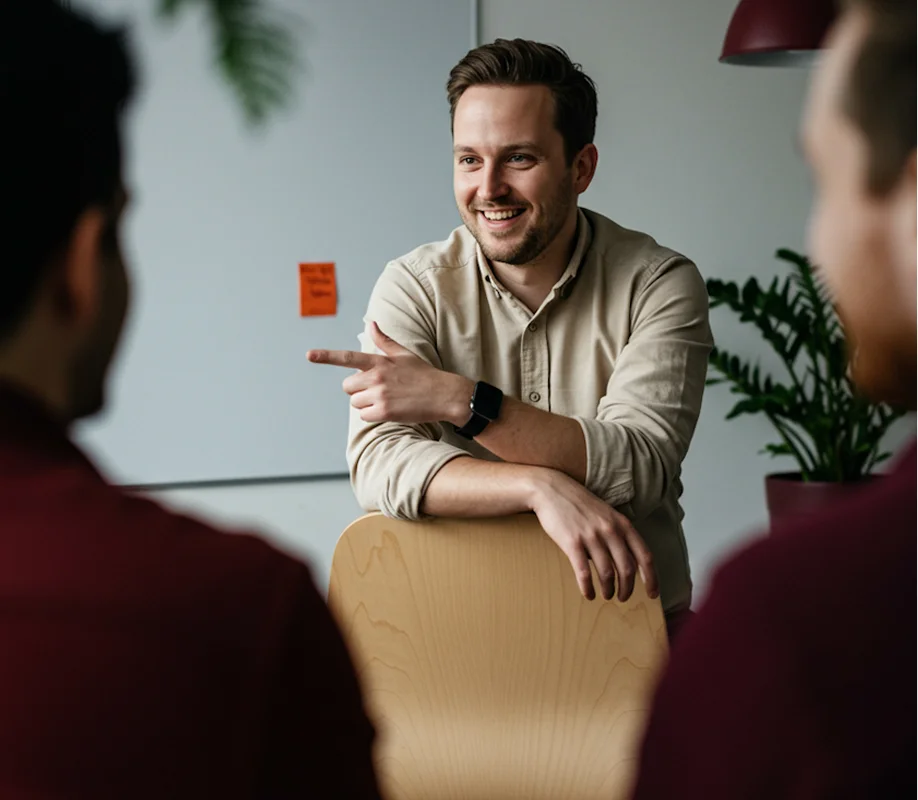 A woman and a man engaged in conversation in front of a whiteboard with business charts and diagrams.