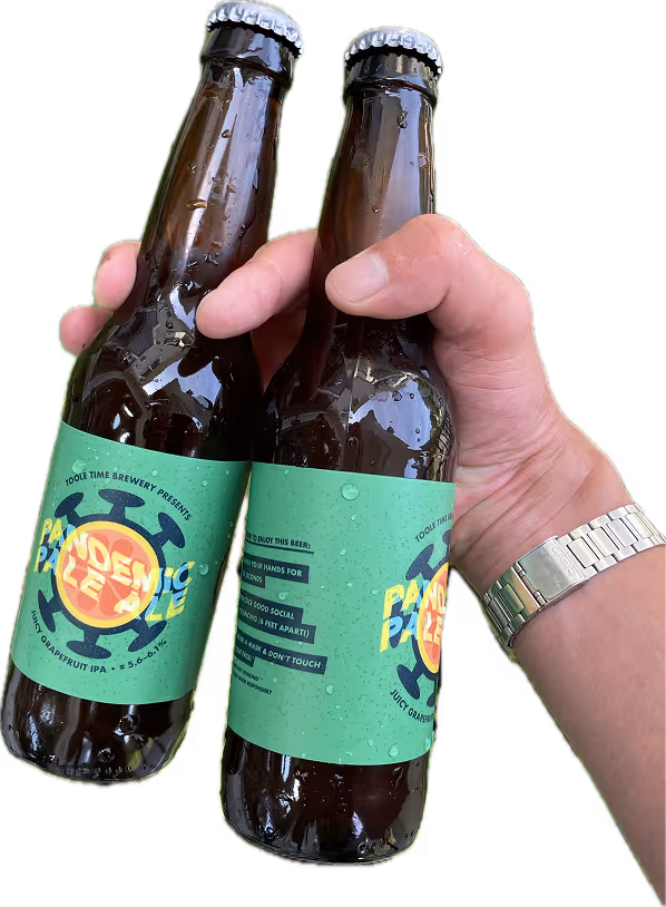 Hand holding two cold beers with the label "Pandemic Pale Ale" made out of an illustration of a germ and a grapefruit slice