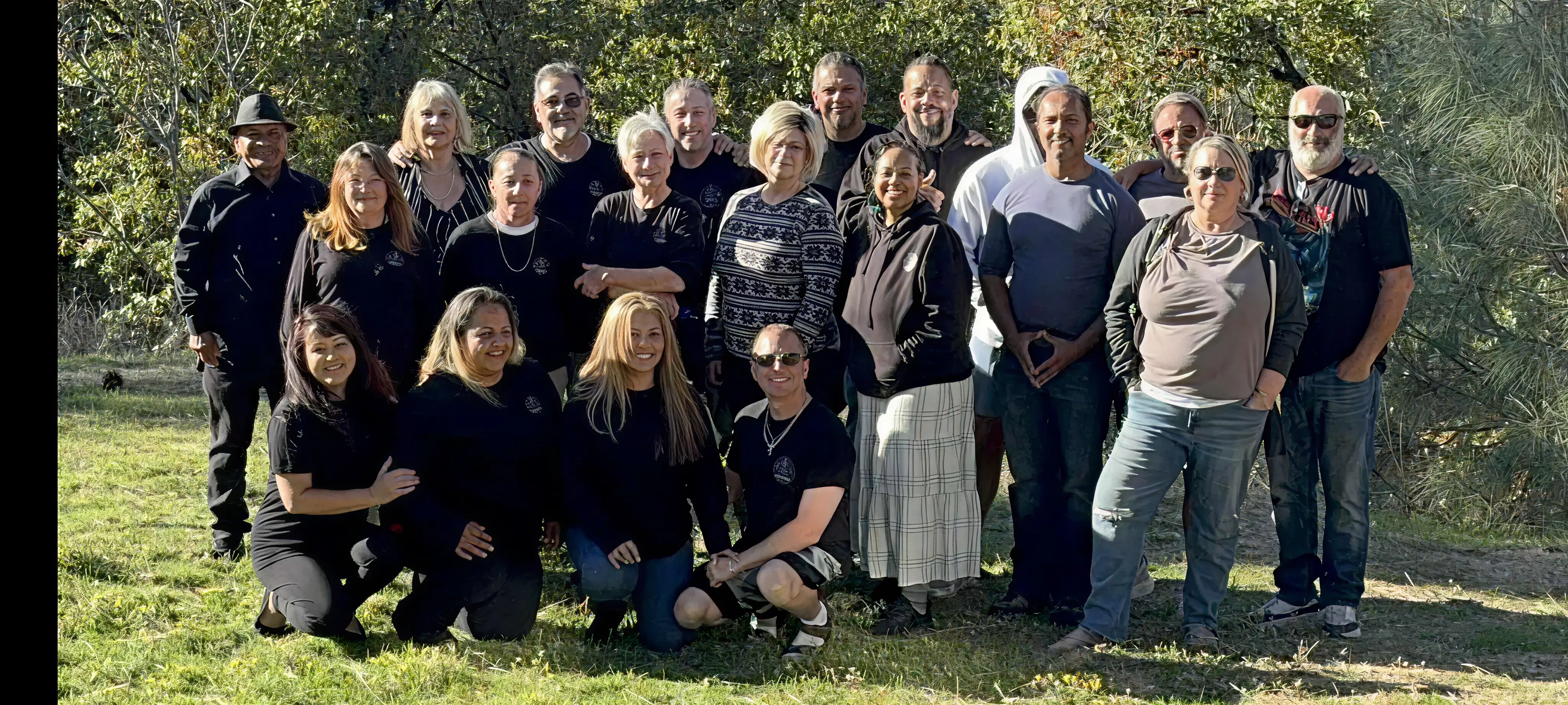A group photo of members from a previous Mind Nexus retreat posing outdoors with the trees behind them