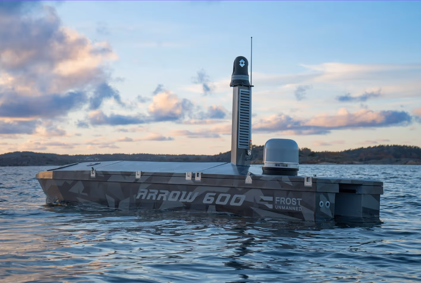 Arrow 600 Frost Unmanned autonomous boat floating on water during sunset with a partly cloudy sky.