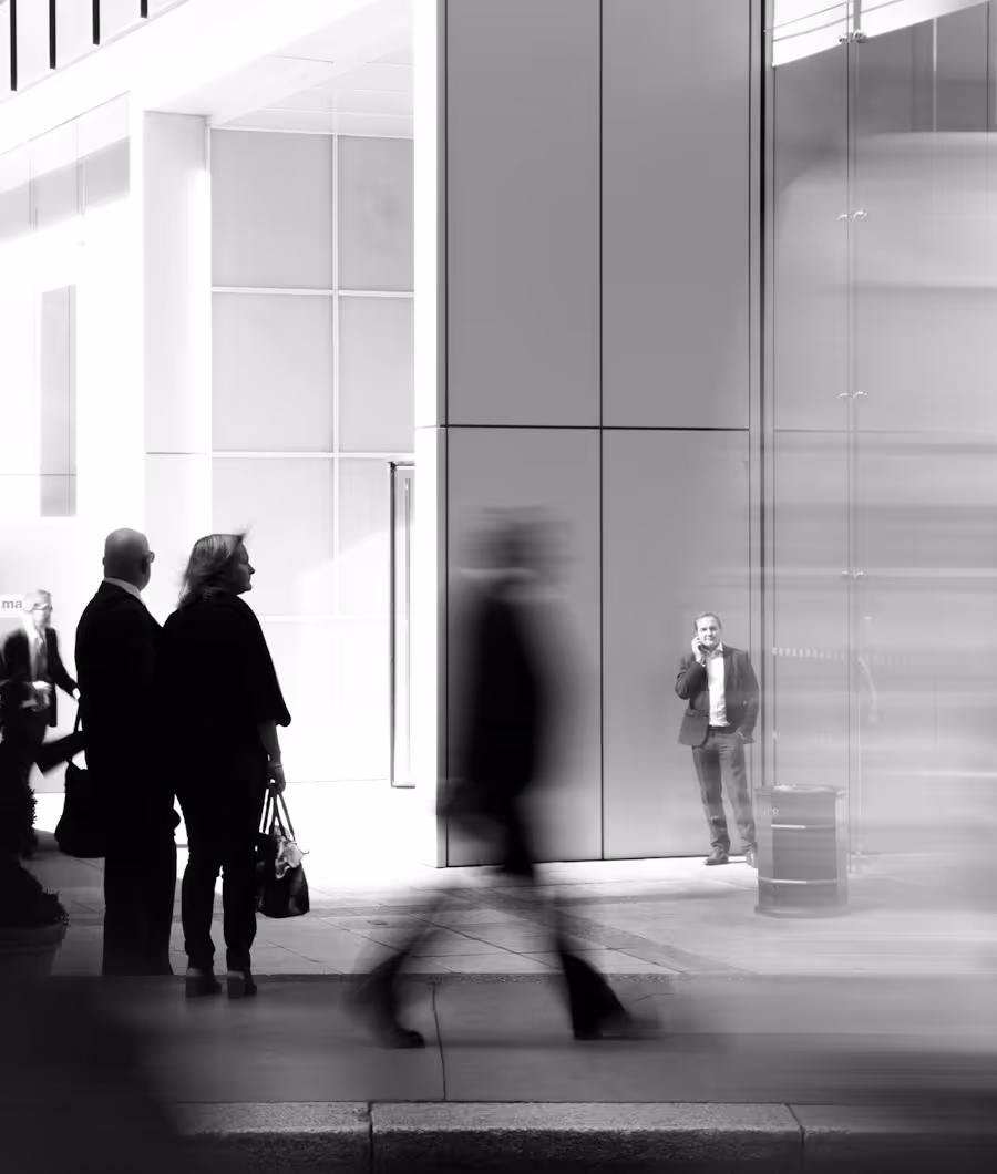 Cadres dirigeants en mouvement devant un immeuble moderne — leadership, dynamisme et recrutement de talents stratégiques pour grandes entreprises financières et technologiques.