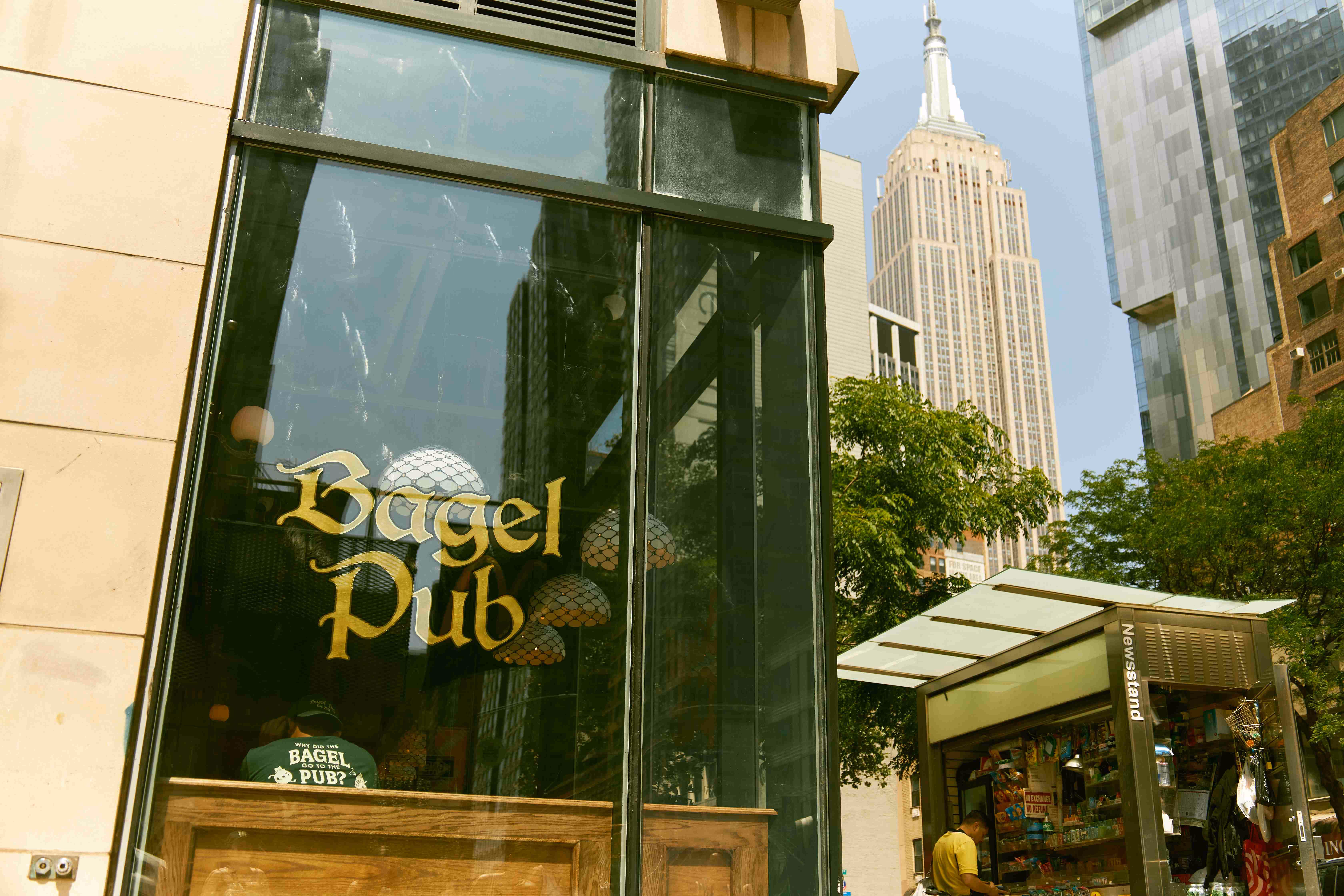 Bagel Pub storefront with Empire State Building in the background, New York City.