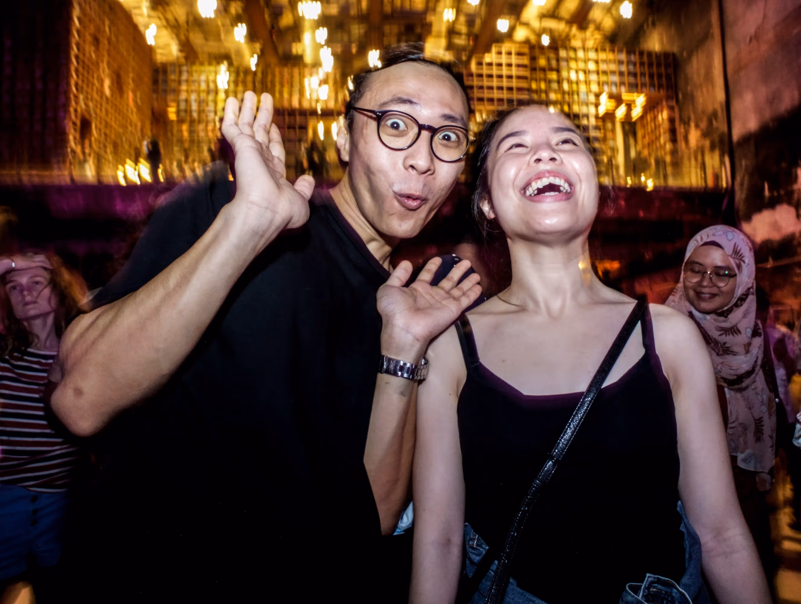 A photo of two guests joyfully posing and laughing at an indoor event, captured by Silver Star Pro — showcasing candid event photography and videography in Dubai with warm lighting and vibrant atmosphere.