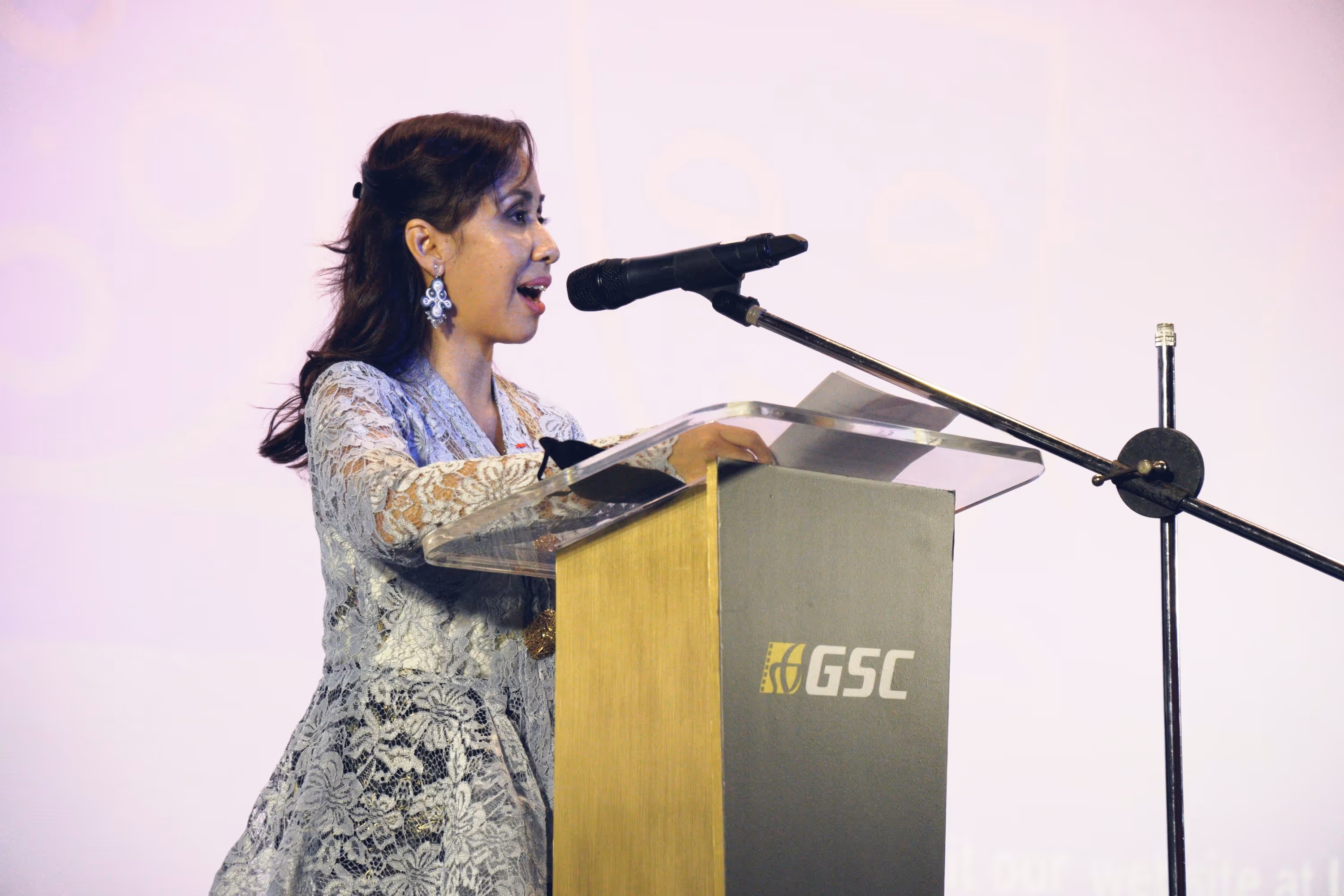 A photo of a woman speaking confidently at a podium during a formal event, captured by Silver Star Pro — representing professional corporate event photography and videography in Dubai with clear lighting and elegant presentation.