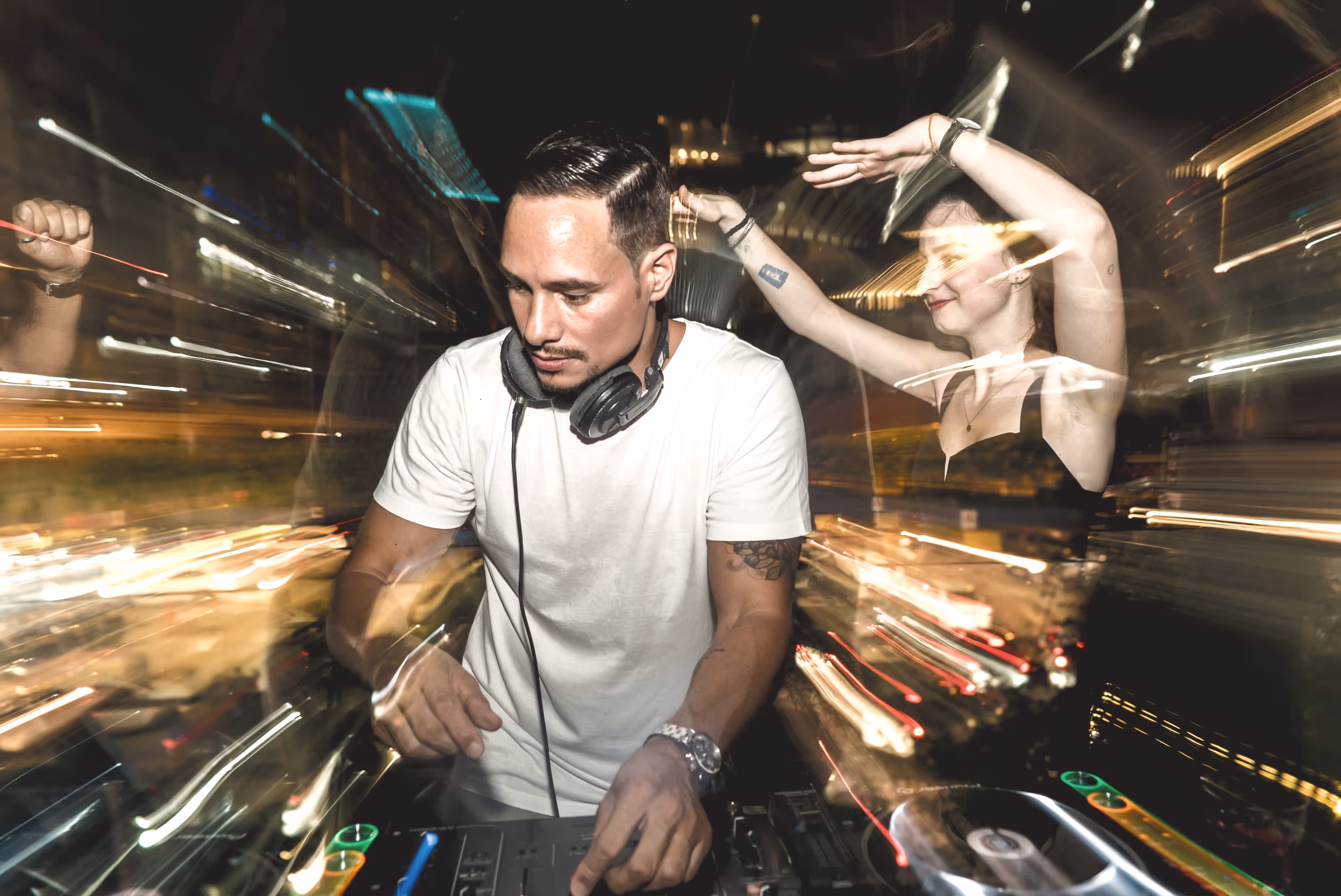 A photo of a DJ performing at a lively night event with dynamic motion blur and city lights, captured by Silver Star Pro — highlighting professional event photography and videography in Dubai with vibrant nightlife energy and artistic visuals.