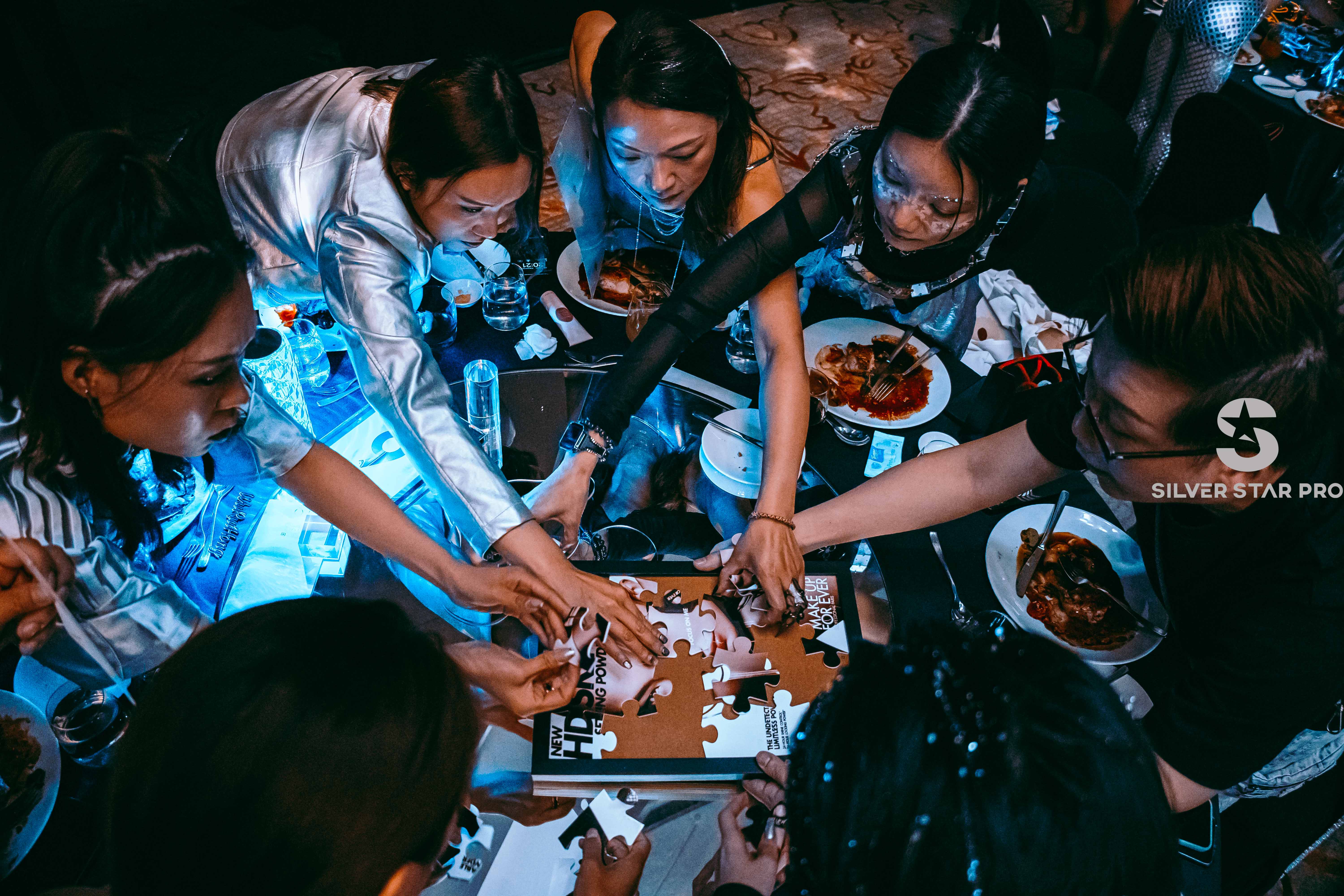 ChatGPT said:  A photo of participants collaborating to complete a MAKE UP FOR EVER puzzle during the 2024 TR APAC Expert Seminar, captured by Silver Star Pro — highlighting dynamic event photography and videography in Dubai with vibrant lighting and candid teamwork moments.