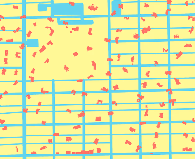 Simplified map showing a grid of blue streets with scattered red building shapes on a yellow background.