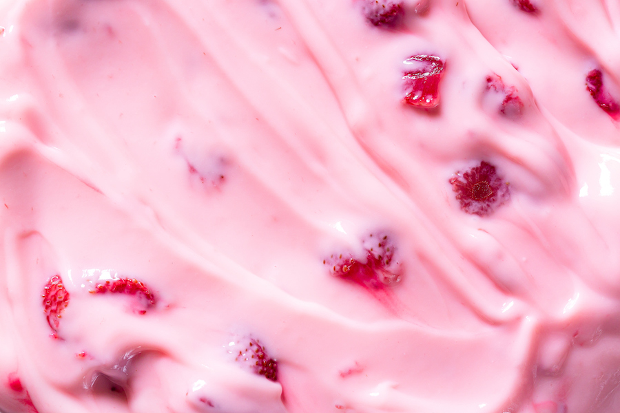 Nahaufnahme von rosa Erdbeerjoghurt mit Fruchtstücken
