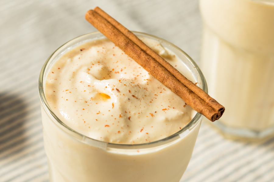 Glas cremiger Shake mit Zimt bestreut und einer Zimtstange obenauf