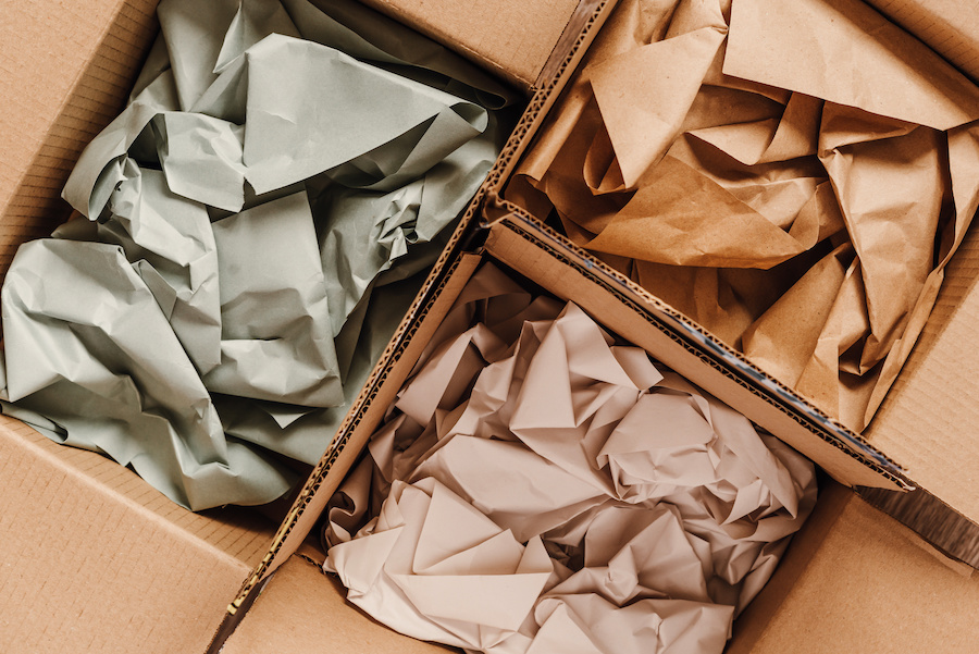 Kartons mit zerknülltem Packpapier in Grau, Braun und Beige, von oben