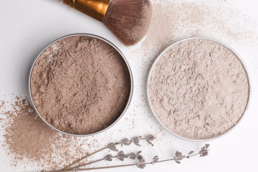 Zwei Dosen loses Gesichtspuder mit Make-up-Pinsel und getrockneten Lavendelzweigen