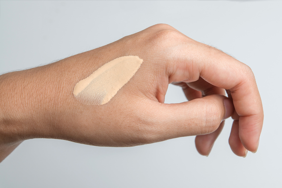 Streifen heller Foundation-Creme auf einem Handrücken