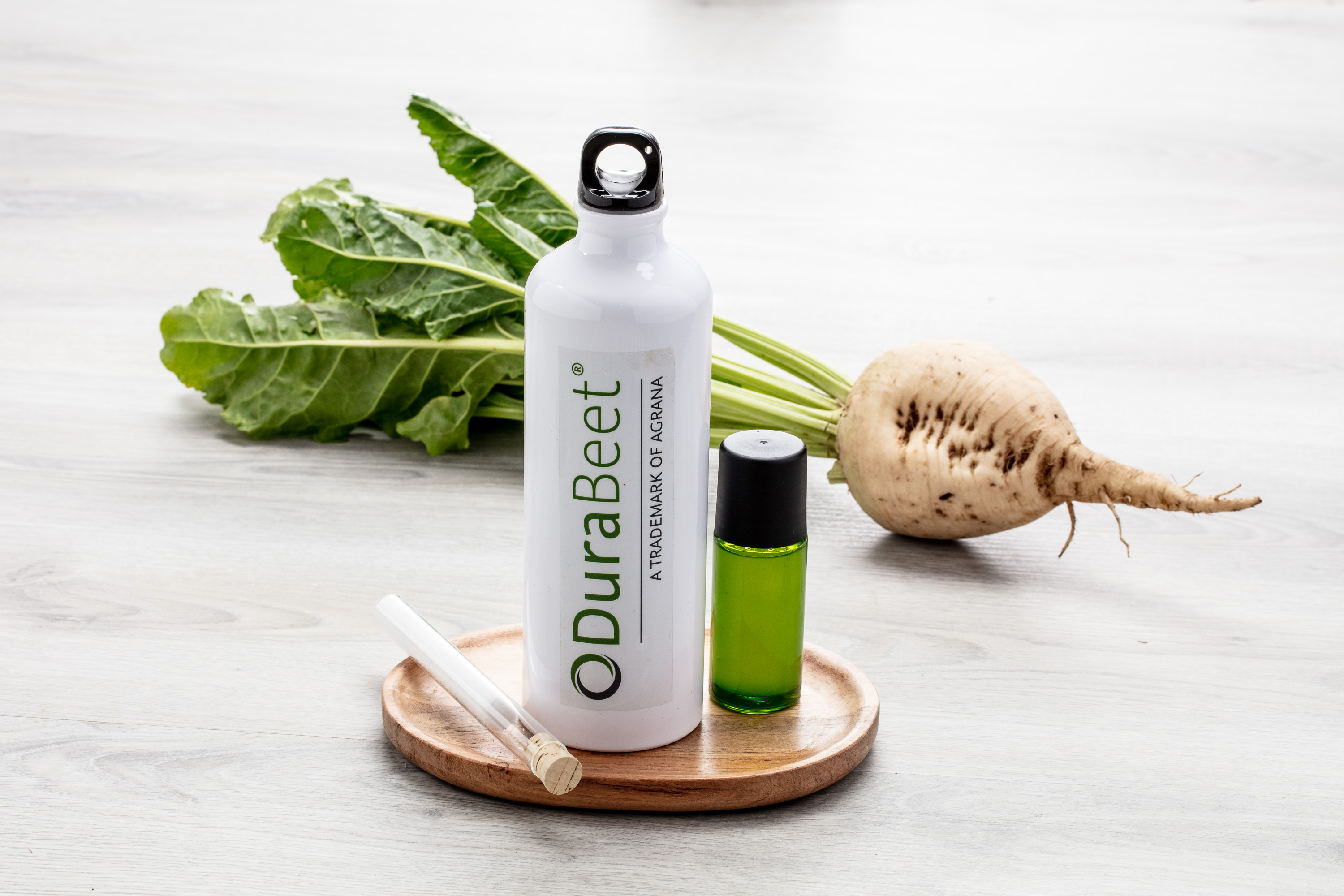 DuraBeet bottle with a vial of green liquid, a sugar beet and beet leaves
