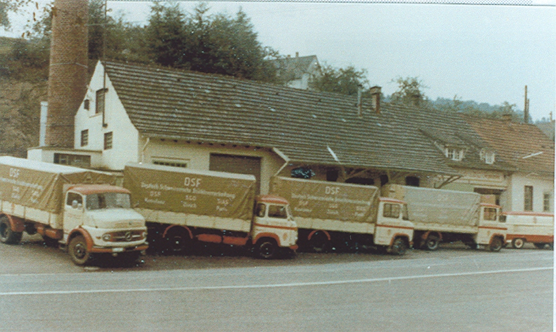 Historic photo of DSF delivery trucks parked in front of the former plant building in Germany [no AI]