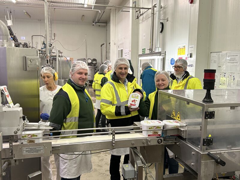 Employees in hairnets and hi-vis jackets at a filling line in the AGRANA Fruit plant in Poland [no AI]