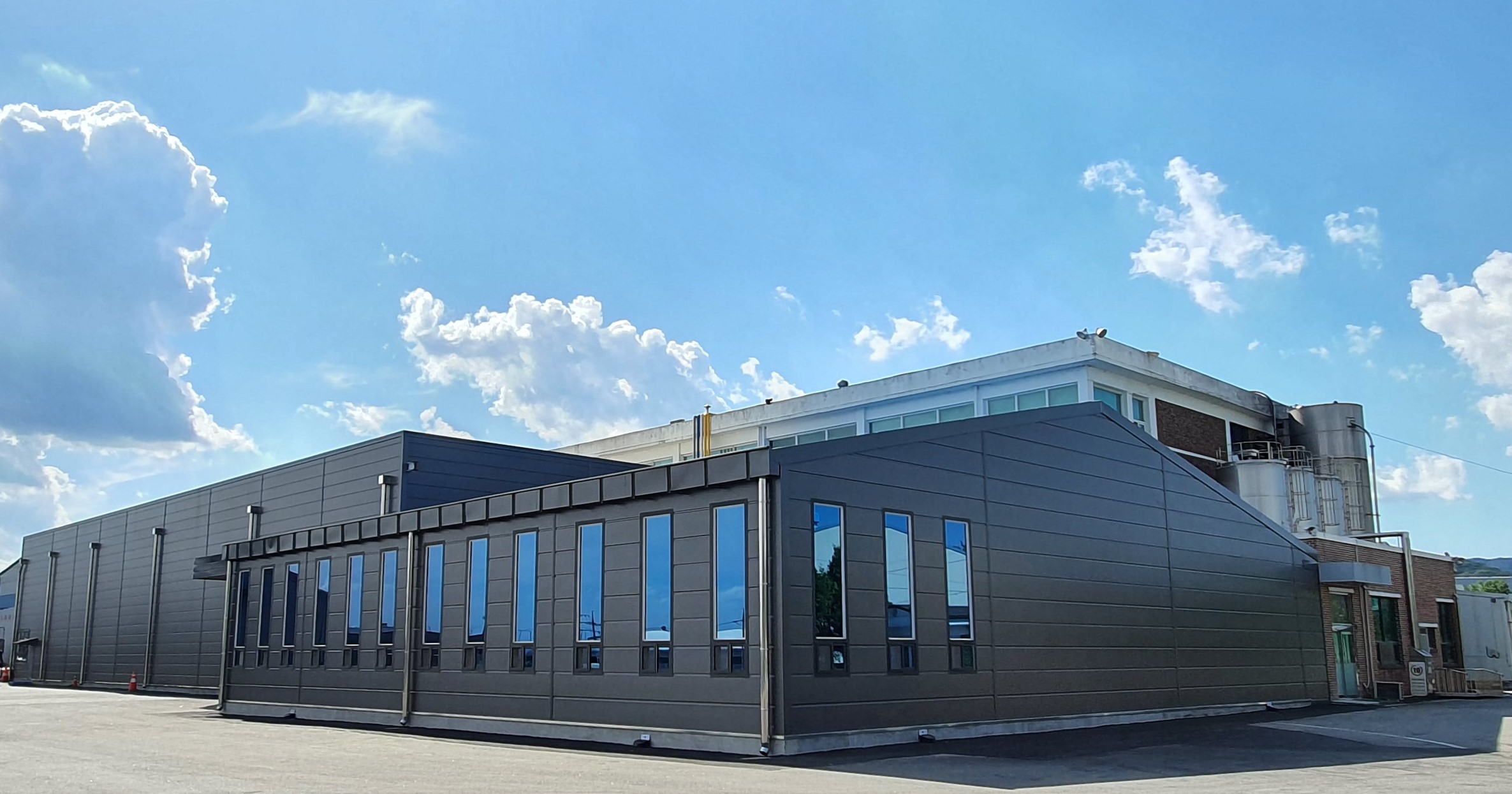 AGRANA Fruit plant in South Korea: modern dark-clad production hall under a blue sky