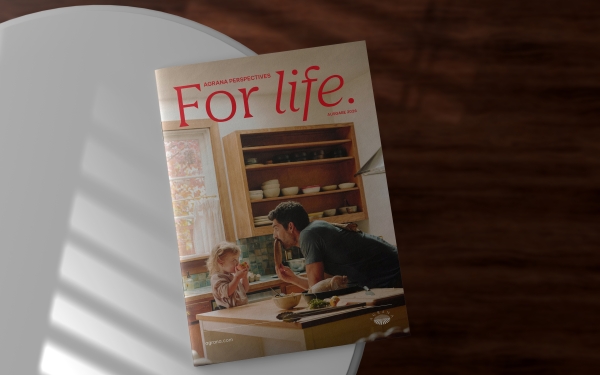 AGRANA-Magazin Perspectives For life. auf einem runden Tisch, Cover mit Vater und Kind in einer Küche