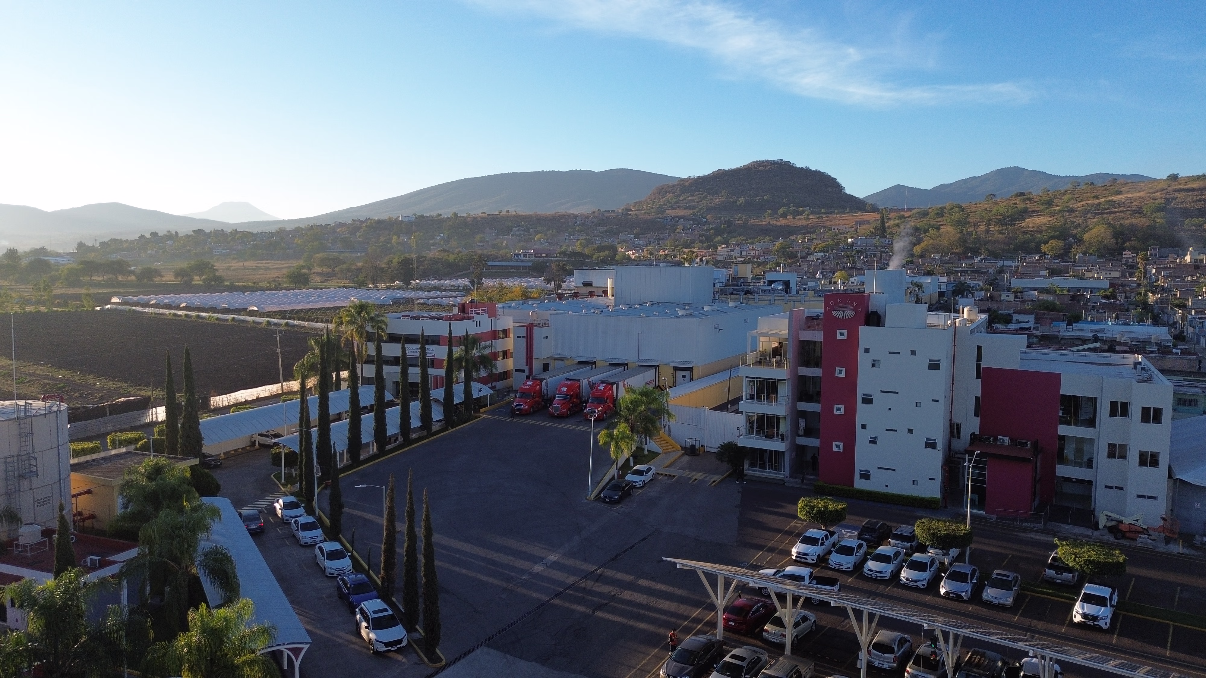 AGRANA Fruit plant in Mexico with red-and-white office building, surrounded by hills [no AI]
