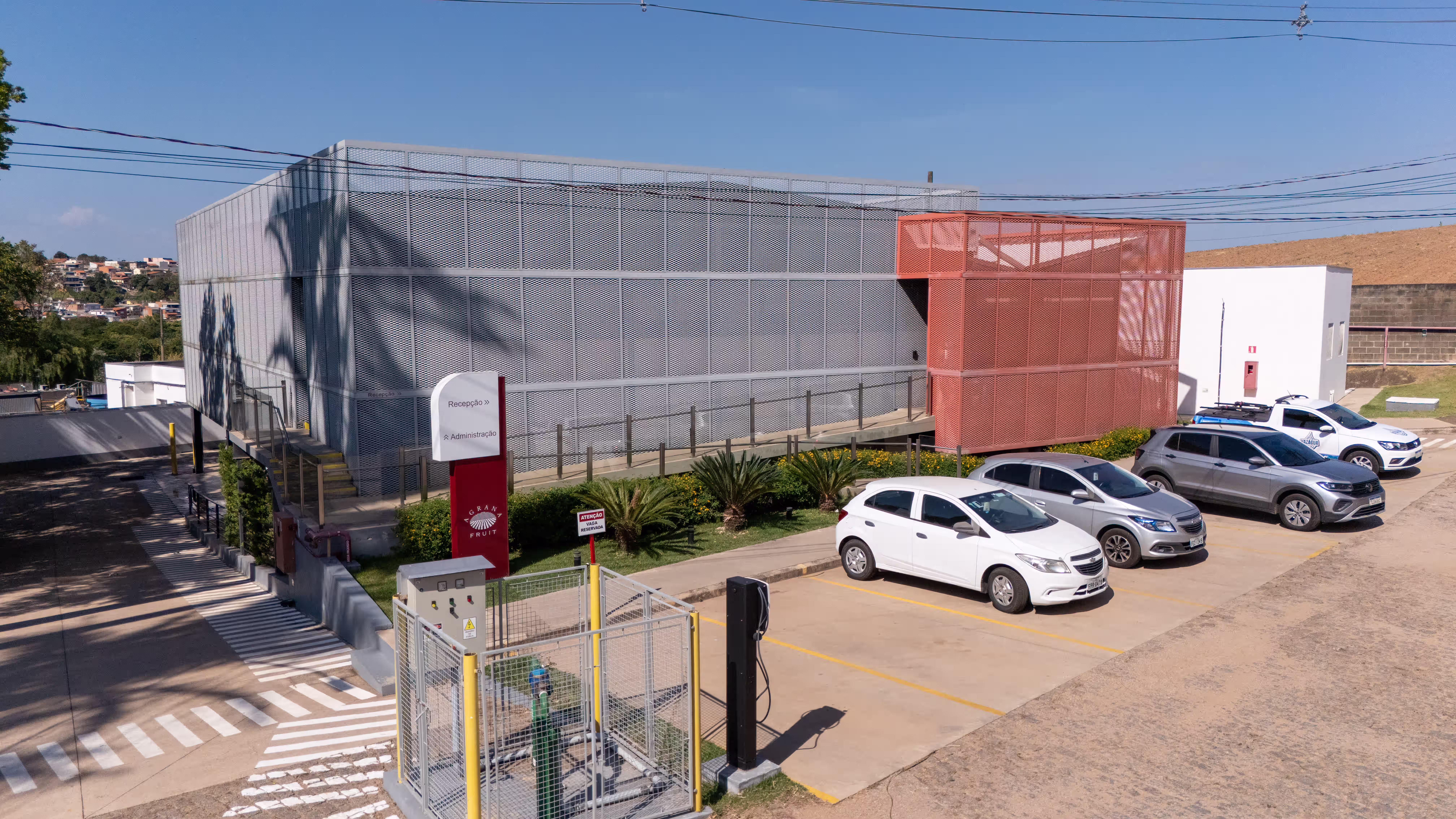 Reception building of the AGRANA Fruit plant in Brazil with perforated metal facade and parking spaces [no AI]