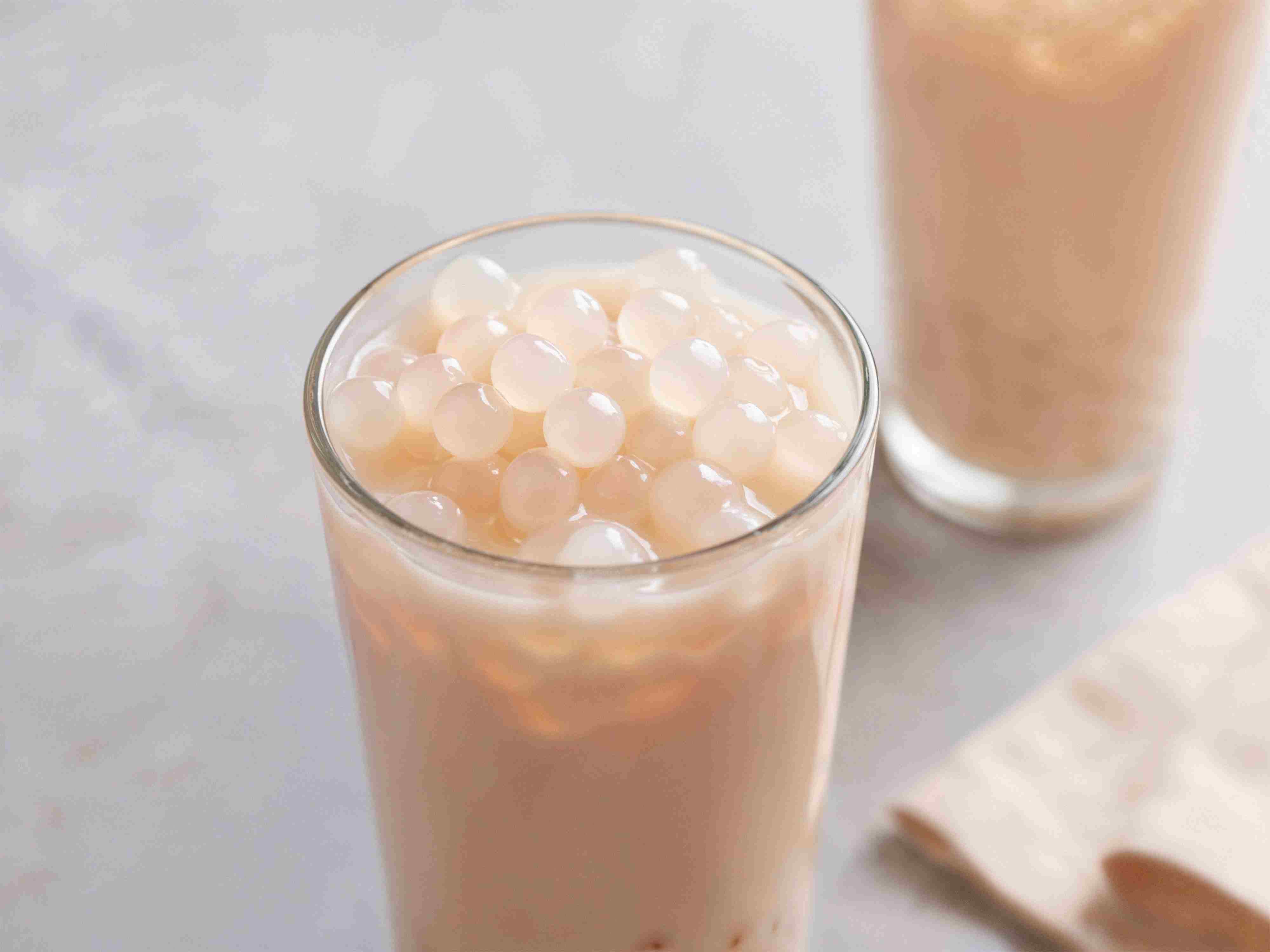 Glas Milchtee mit durchsichtigen Popping-Perlen obenauf