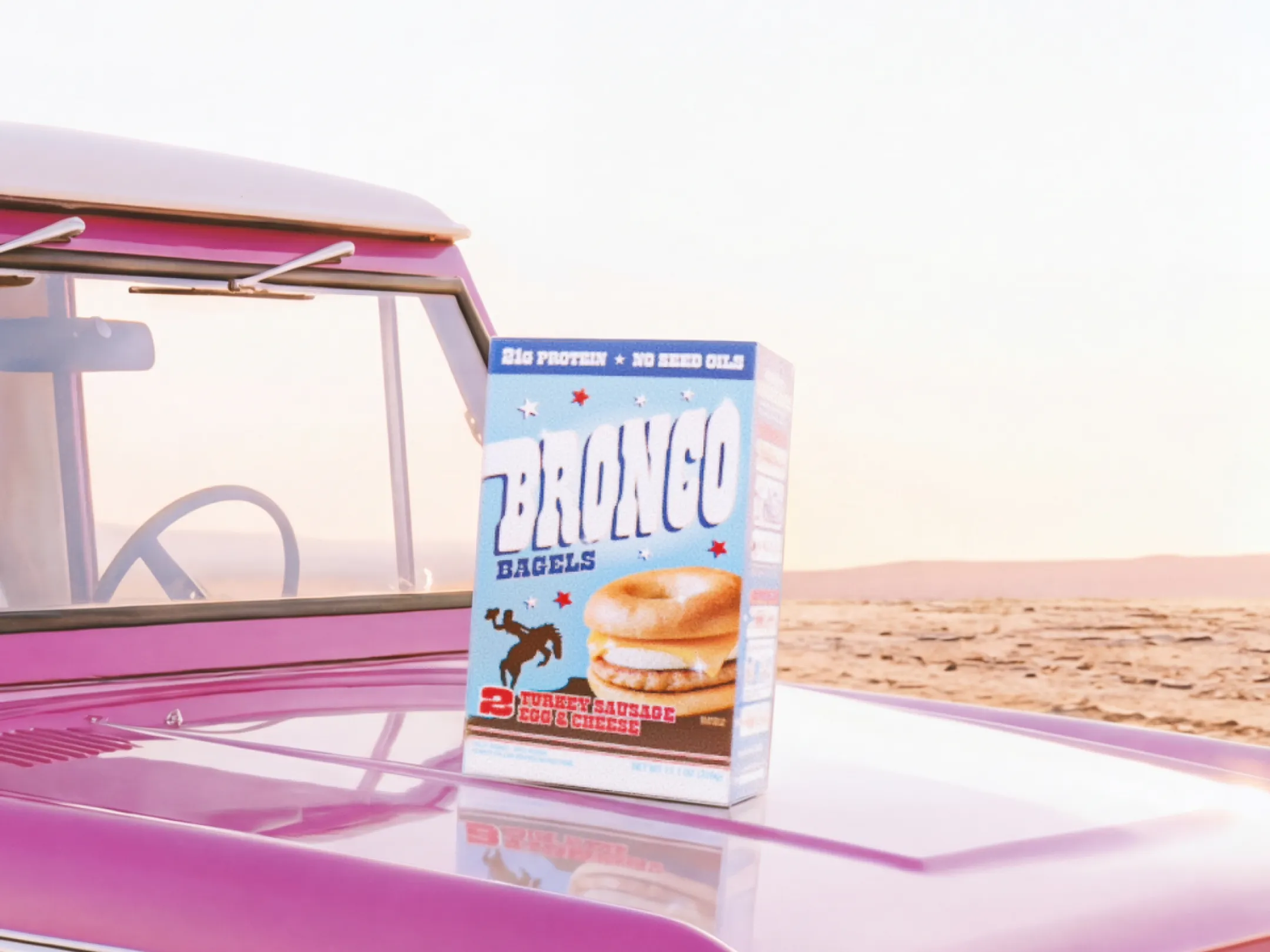 BRONCO Bagels box on the hood of an old truck in the desert